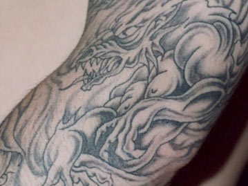 Full Arm Black and White Dragons and Skulls Tattoo