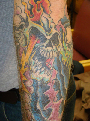 blake shelton tattoo on forearm. Flaming Skulls Arm Tattoo